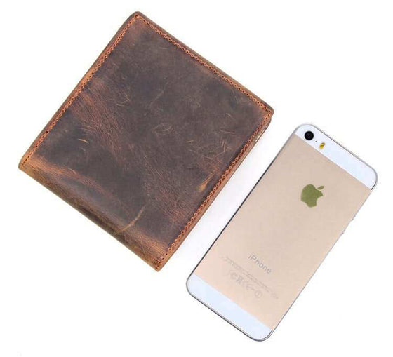 Men's luxury leather wallet with a phone for size comparison.