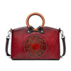 Genuine leather handbag with embossed geometric pattern and wooden handle.