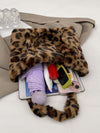 Leopard fluff handbag open with various items inside, showcasing stylish design and practicality for everyday use.