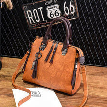  Luxury women's crossbody handbag with soft material, adjustable strap, and spacious interior.